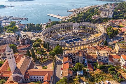 Antiguo anfiteatro romano destacando sobre los edificios colindantes en Pula