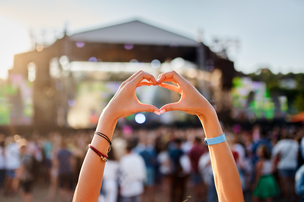 Espectador con las manos en forma de corazón durante un concierto